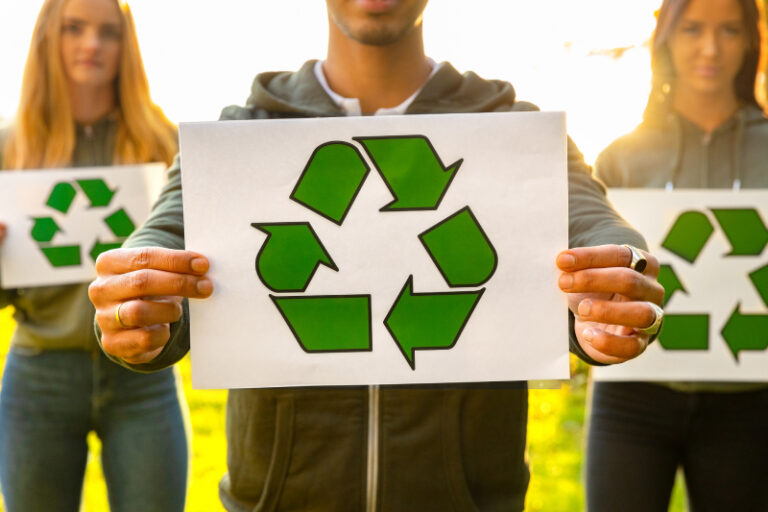 young-volunteers-holding-recycling-symbol-placard-2021-08-27-13-37-31-utc (1)